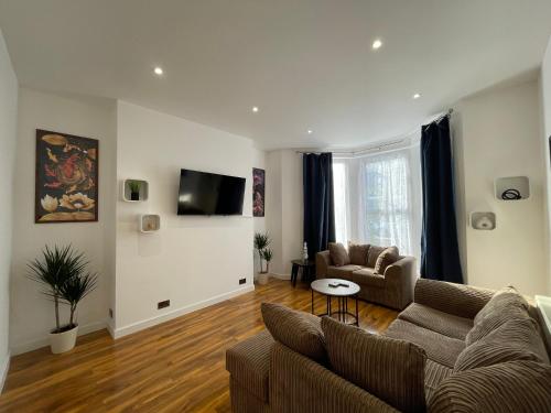 a living room with a couch and a tv at Station House Plymouth in Plymouth