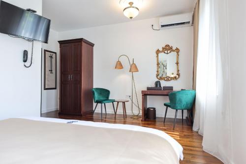 a bedroom with a bed and a desk and chairs at Villa 1927 in Belgrade