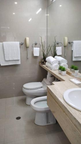a bathroom with a toilet and a sink with towels at Suite PRIVADA Torre D CCCT Caracas in Caracas
