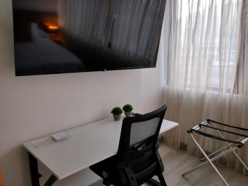 加拉加斯的住宿－Suite PRIVADA Torre D CCCT Caracas，一张带两把椅子的白色书桌和窗户
