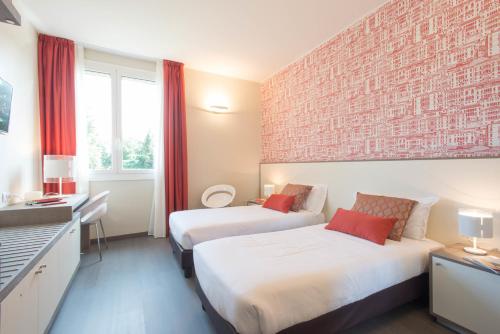 ミラノにあるHotel Tiziano - Gruppo Mini Hotelのレンガの壁のホテルルーム内のベッド2台