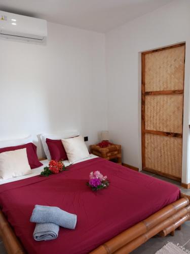 a bedroom with a large bed with flowers on it at Terei-Here Bungalow Airport in Avae