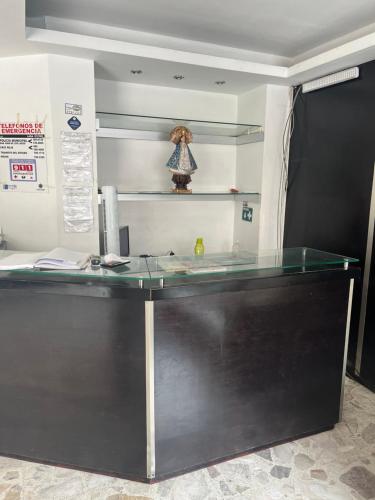 - un bureau avec un comptoir en verre dans la chambre dans l'établissement HOTEL JERUSALEM, à San Juan de los Lagos