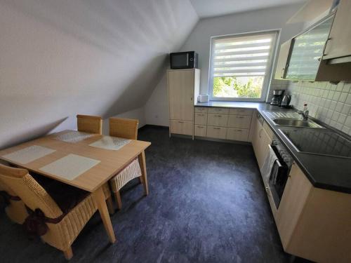 een kleine keuken met een houten tafel en een wastafel bij Monteurzimmer, Ferienwohnung in Delmenhorst