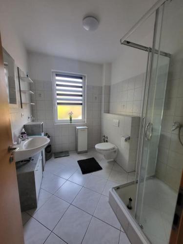 een badkamer met een douche, een toilet en een wastafel bij Monteurzimmer, Ferienwohnung in Delmenhorst