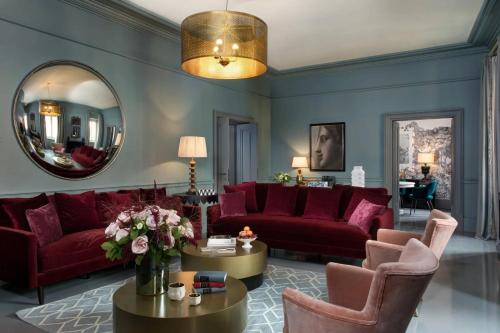 a living room with red furniture and a mirror at Luxury Flat in London