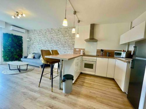 une cuisine avec une table et un salon dans l'établissement Jolie T2 40m2 hôpitaux avec terrasse et parking, à Montpellier