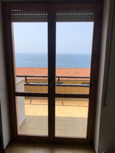 an open glass door with a view of a balcony at Il Rifugio sul Mare in Terme Luigiane