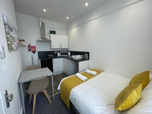 a small room with a bed and a kitchen at Station House Plymouth in Plymouth