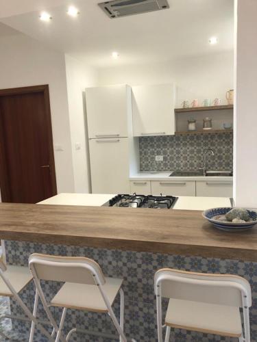 a kitchen with a counter with two chairs and a stove at Il Rifugio sul Mare in Terme Luigiane