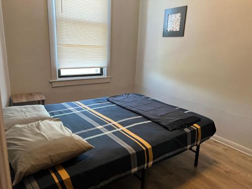 a small bedroom with a bed in a room with a window at Ethan 3 rooms in Chicago