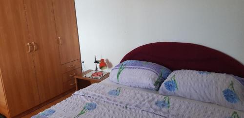 a bed with two pillows on it in a bedroom at Apartments Vučko in Povile