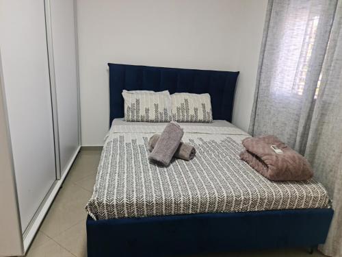 a blue bed with two pillows on top of it at House By The Beach in Eilat