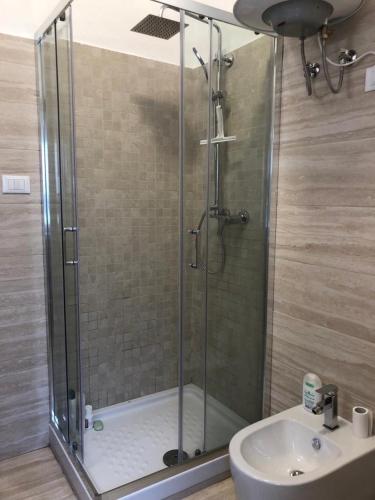 a shower with a glass door next to a sink at Il Rifugio sul Mare in Terme Luigiane