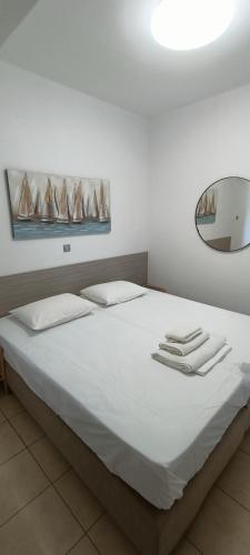 a bedroom with a white bed with towels on it at Christinas 3 in Nerántza