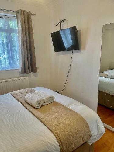 a bedroom with a bed and a tv on the wall at Charming double-bedroom in London Flat in London