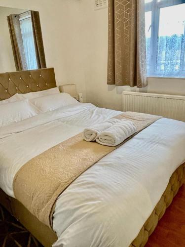 a large white bed with two towels sitting on it at Charming double-bedroom in London Flat in London