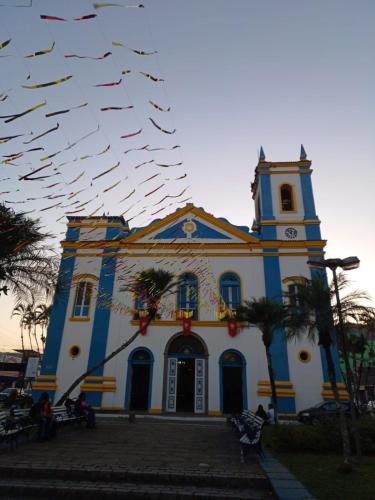a blue and white church with a flock of birds at Hostel Trópico de Capricórnio - Tenório in Ubatuba