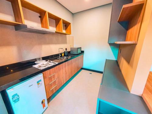 a small kitchen with a sink and a refrigerator at Globo Lar Studios in Limeira