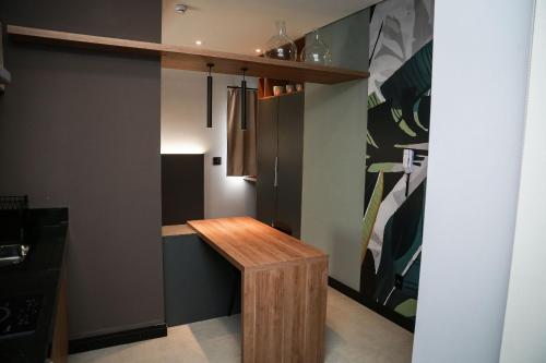 a kitchen with a wooden table in a room at Globo Lar Studios in Limeira