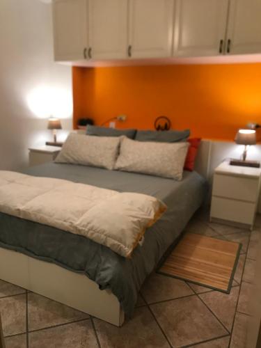 een slaapkamer met een bed met een oranje muur bij App G&G in Sagron Mis