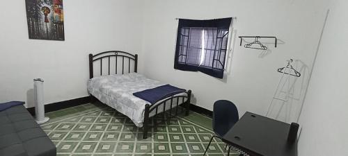 a small bedroom with a bed and a window at Hostal Casa Azul, sencilla in Orizaba