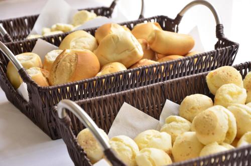 two baskets filled with bread and rolls on a table at Rede Andrade San Martin in Curitiba