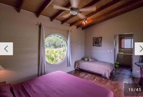 a bedroom with two beds and a large window at Eden Tica Lodge in Uvita