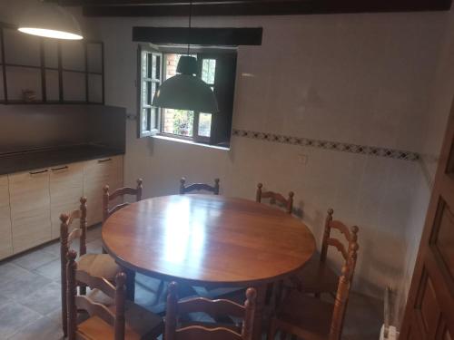 a kitchen with a wooden table and chairs at Casa Rural Erre Q Erre in Oreña