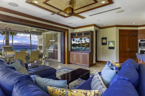 un soggiorno con divano blu e TV di Wailea Beach Villa B202 condo a Wailea