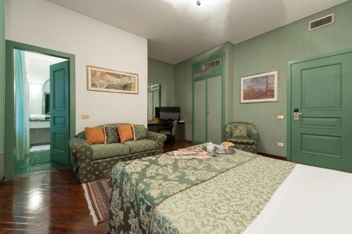 a hotel room with a bed and a couch at Hotel Villa Giulia in Tortona