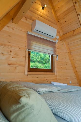 two beds in a log cabin with a window at Bungalow Jajce 1 in Jezero