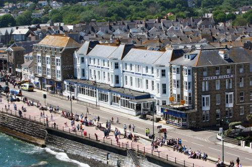 a group of people walking on a street in a city at The Queens Hotel in Penzance