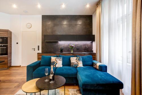 een woonkamer met een blauwe bank en een tafel bij Luxury Residence Kmochova in Praag