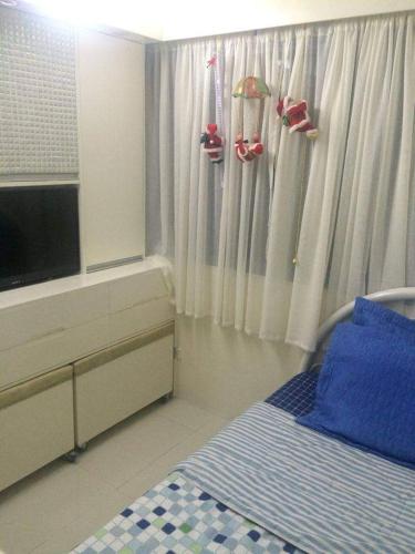 a bedroom with a bed and a tv and a window at Roxas Blvd Stunning Studio Condo Near US Embassy in Manila