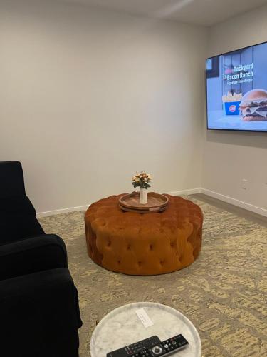a living room with a table and two remote controls at Grande Villa in Calgary
