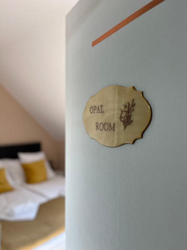 a wooden sign on a wall next to a bed at Aventurin House *** in Révfülöp