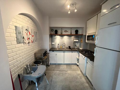 a kitchen with white cabinets and a white refrigerator at Aventurin House *** in Révfülöp