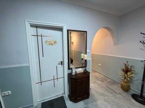 a bathroom with a door and a mirror on the wall at Aventurin House *** in Révfülöp