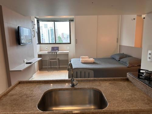 a kitchen with a sink and a bedroom with a bed at Flat localizado a 200m Shopping Recife, bem Perto da Praia de Boa Viagem e com Wi-Fi 400Mbps in Recife
