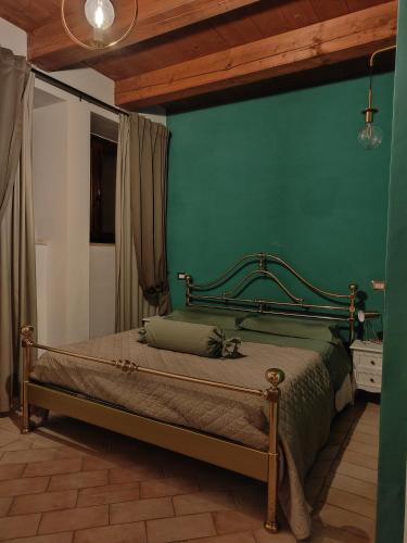 una camera con un letto con una parete verde di Dolci Soggiorni a Loreto