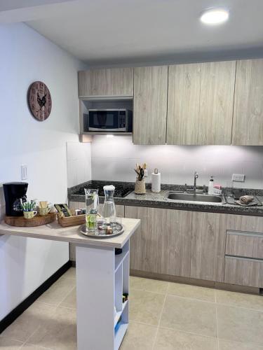 uma cozinha com armários de madeira e uma bancada em Maravilloso alojamiento para tu familia em Santa Rosa de Cabal