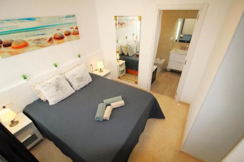 1 dormitorio con 1 cama con 2 toallas en Panorama Benidorm Torre Montecarlo, en Benidorm