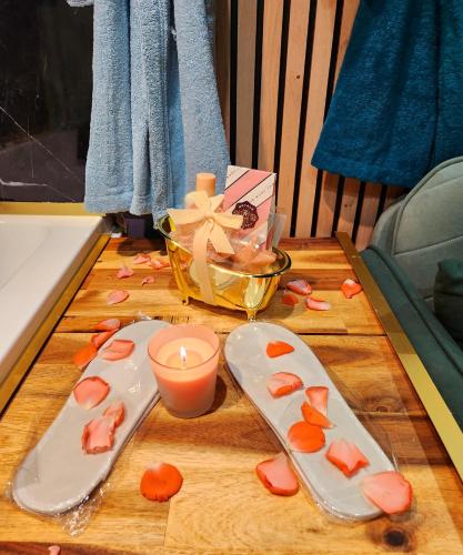 une table avec deux assiettes et une bougie et un bol de fleurs dans l'établissement Jungle House à 10 min de Disneyland -Taille Chambre-, à Condé-Sainte-Libiaire