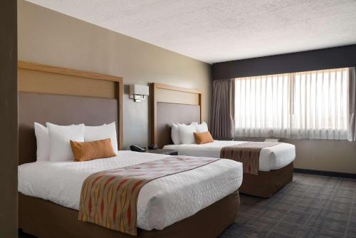 a hotel room with two beds and a window at Best Western Plus Landmark Hotel in Ballard