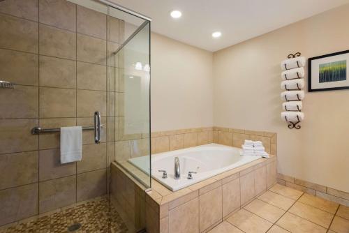 W łazience znajduje się wanna i przeszklony prysznic. w obiekcie Best Western Plus Landmark Hotel w mieście Ballard