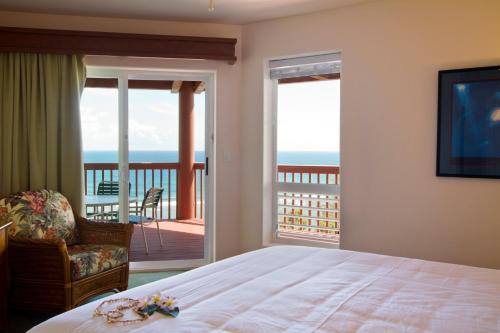 1 dormitorio con 1 cama y balcón con vistas al océano en Club Wyndham Shearwater en Princeville