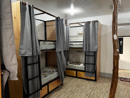 a room with three bunk beds in a room at The Backyard Inn in Moalboal