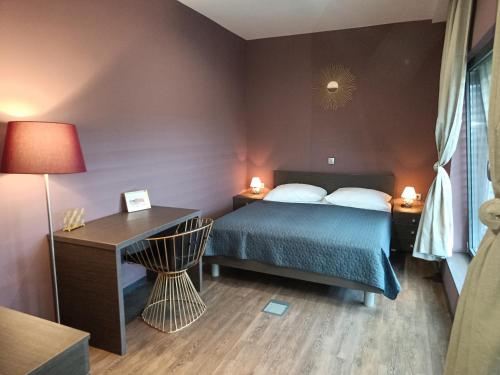 a bedroom with a bed and a desk with a lamp at Nitro Rooms in Ljubljana