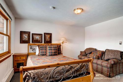 1 dormitorio con 1 cama y 1 sofá en Ultimate Group Getaway, Spacious Multi-Level Retreat Close to Downtown SSET13, en Breckenridge